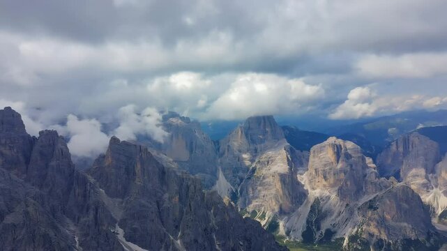 Majestic rocky mountain peaks surrounded by low clouds under soft morning light, creating a peaceful and awe-inspiring landscape full of natural wilderness beauty and calm