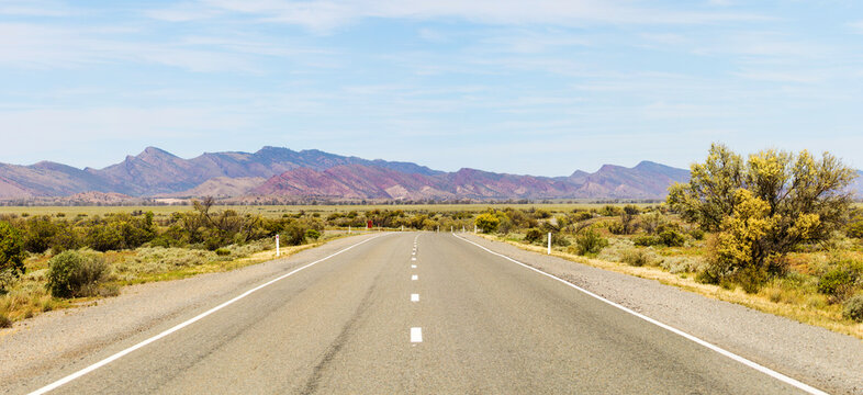 Road heading towards rugged mountains