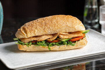 Portion of ciabatta sandwich with chicken and salad