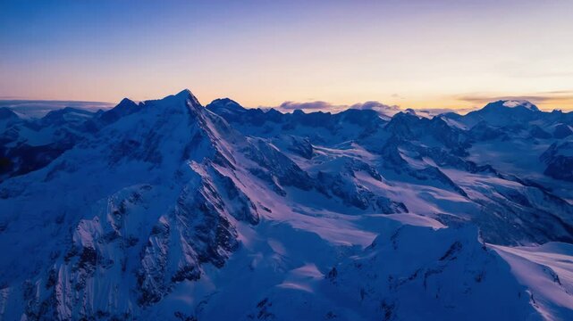 Majestic snow-covered mountain range with glowing sunset sky and sharp icy peaks under fading evening light, showing the pure and peaceful beauty of winter at high altitude