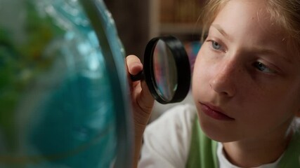 Smart clever curious Caucasian little girl schoolkid child school kid overworked schoolgirl pupil student using magnifying glass looking globe world map research project studying learn indoor library - Powered by Adobe