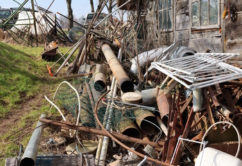 Scrap metal pile near an old rural house.
