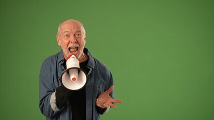 A mature man with gray hair passionately speaks into a megaphone against a green screen background,...