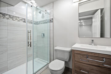Bathroom with a white toilet and sink, and a glass shower door