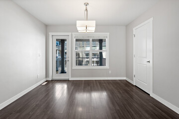 Large, empty room with a wooden floor and a window