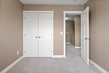 White bedroom with a white door and a white closet