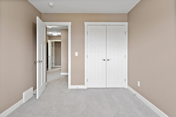 White bedroom with a white door and a white closet