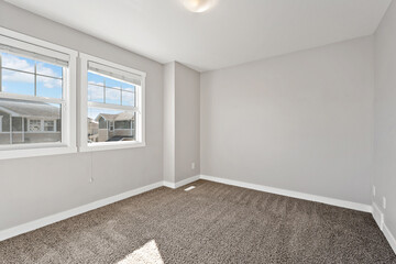 Very clean and empty room with a tan wall and tan carpet