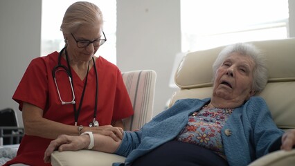 A caregiver gently massages the arm of an elderly woman, offering relaxation and comfort in a...