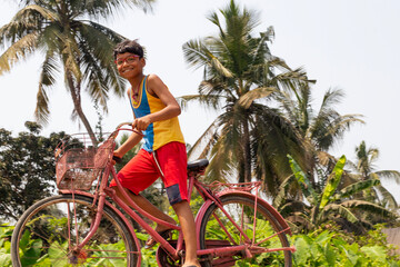 Young boy riding bicycle at village