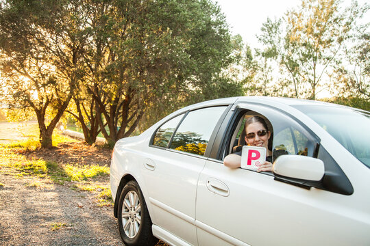 Teenager holding provisional P1 plate out car window