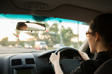 Teen girl driving car through traffic lights
