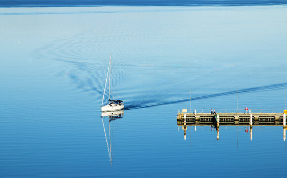 Boat coming into dock with ripples in wake