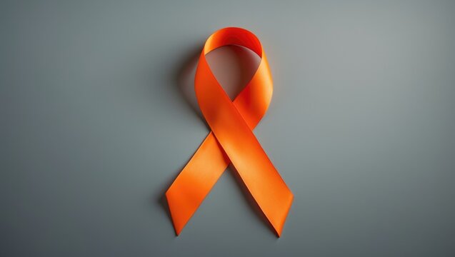 Orange awareness ribbon on gray backdrop, text space available - Powered by Adobe