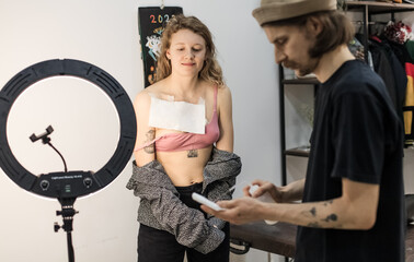 Tattoo artist creating a custom design for a young woman in a cozy Tbilisi studio. Details of the...