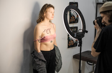 Tattoo artist creating a custom design for a young woman in a cozy Tbilisi studio. Details of the...