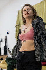 Tattoo artist creating a custom design for a young woman in a cozy Tbilisi studio. Details of the process, tattoo tools, ring light photography, and creative atmosphere