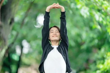 Zelfklevend Fotobehang 新緑　女性　伸び　深呼吸 © naka