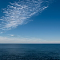 Obraz premium Calm ocean scene under a clear blue sky with wispy clouds; perfect for travel or serenity themed projects
