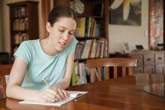 Teen girl doing math work on the table at home