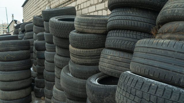 Storage of discarded old car tires outdoors, showcasing a pile of used tires ready for recycling. Highlighting environmental concerns and rubber waste management