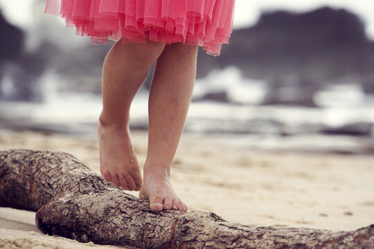 Close up of five year olds feet walking on log