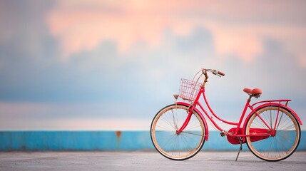 Naklejka premium Vintage Red Bicycle on Coastal Background at Sunset Sky Colors
