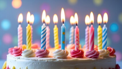 Birthday cake featuring burning candles in focus with a background setting