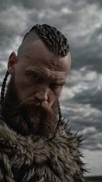 Guerrier viking au regard mena&ccedil;ant v&ecirc;tu de fourrure sous un ciel orageux

