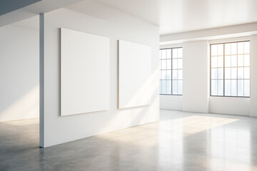 Two blank vertical posters hanging on a white wall in a bright modern gallery interior with large windows and light reflections on the floor.