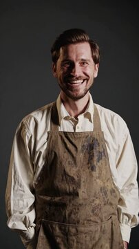 Artisan souriant en tablier tach&eacute; sur fond neutre

