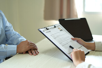 A female office executive woman hand holding resume, talk to job applicants for job interviews about careers in the meeting room to analyze data before job interviews regarding personnel recruitment.