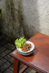 Delicious Bowl of Savory Yakiniku Meat With Fresh Lettuce on Wooden Table in a Rustic Outdoor Setting