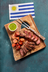 Celebrating independence day with a traditional Uruguayan asado featuring grilled meats and the national flag