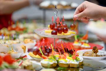 woman hands of a waiter prepare food for a buffet table in a restaurant
