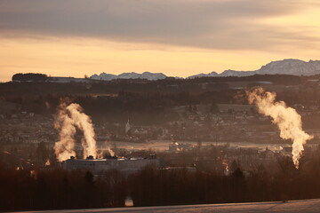 The smoke from a factory is rising into the sky, creating a hazy atmosphere