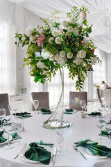 A composition of delicate flowers on the tables in the banquet hall.