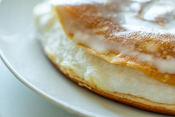 Slice of omelette poulard with pancakes on a light background. close-up