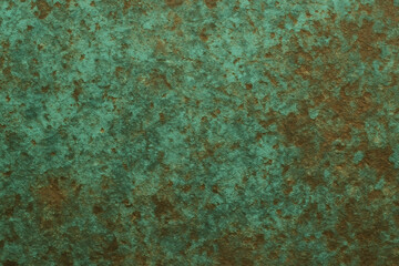 A close up of a textured surface with green and brown color variations and an uneven appearance