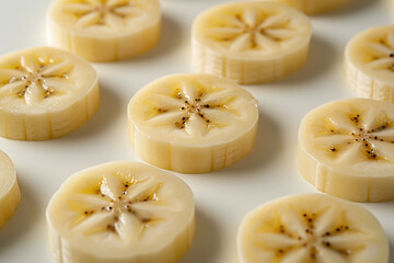 Several Sliced Plantain Fruits Displaying Central Seed Patterns on White Backdrop