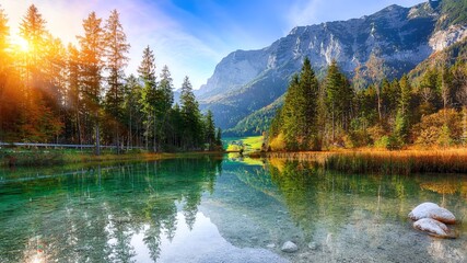 A serene landscape showcasing a tranquil lake surrounded by lush green trees and majestic mountains, illuminated by the warm glow of sunlight, creating a peaceful and picturesque s