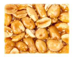 Close up of chikki peanut brittle pieces showing rich texture and caramelized peanuts on transparent background