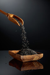 Fototapeta na wymiar Black sesame on a black reflective background.
