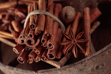 Cinnamon sticks, anise, and nutmeg on a wooden table.