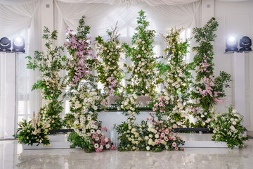 table for the newlyweds in the banquet hall decorated with flower arrangements. 