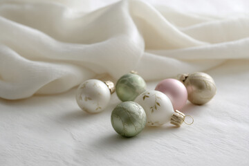 serene arrangement of delicate christmas ornaments on soft white background