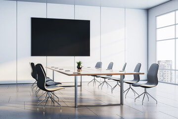Modern corporate meeting room with sleek chairs, wooden table, large wall-mounted screen and city...