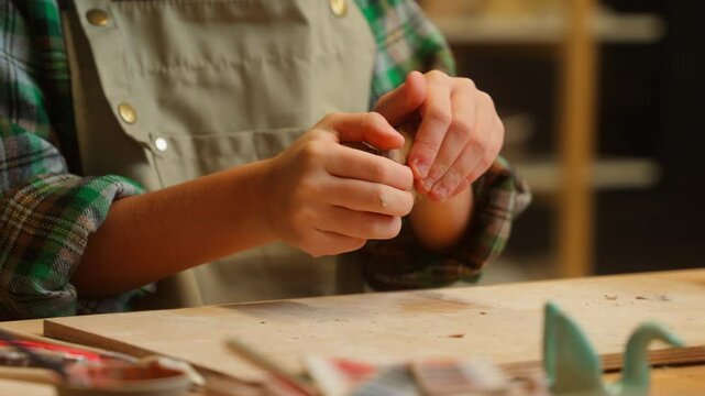 Close up happy Caucasian little girl child kid student artist potter daughter in apron craftsperson preparing knead porcelain clay material pottery class make shape artwork create art indoors workshop