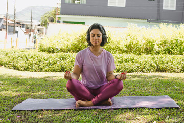 Mulher meditando e praticando ioga no parque