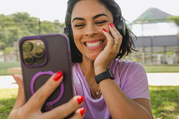 Jovem fazendo video chamada no parque 